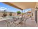Covered patio with an outdoor dining set adjacent to the refreshing pool at 14393 N 101St St, Scottsdale, AZ 85260
