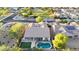 High aerial view of a neighborhood showing tile roofs and backyards, including a home with a pool and turf at 16229 W Berkeley Rd, Goodyear, AZ 85395