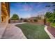 Expansive backyard with lush artificial turf, an outdoor kitchen and a pool at 16229 W Berkeley Rd, Goodyear, AZ 85395