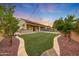 Expansive backyard with lush artificial turf, an outdoor kitchen and a pool at 16229 W Berkeley Rd, Goodyear, AZ 85395