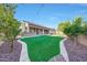 Backyard with beautiful landscaping, green grass, and a covered patio at 16229 W Berkeley Rd, Goodyear, AZ 85395