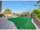 A beautifully landscaped backyard featuring artificial turf, pavers, and string lights at 16229 W Berkeley Rd, Goodyear, AZ 85395