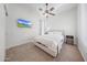 Bedroom with neutral carpet, ceiling fan, natural light, and television at 16229 W Berkeley Rd, Goodyear, AZ 85395