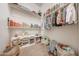 Organized walk-in closet with built in shelving and two baskets on the floor at 16229 W Berkeley Rd, Goodyear, AZ 85395