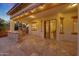 Inviting covered patio with stone kitchen area, tiled flooring, and sliding glass doors leading inside at 16229 W Berkeley Rd, Goodyear, AZ 85395