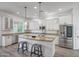 Open kitchen features an island with barstool seating and stainless steel appliances at 16229 W Berkeley Rd, Goodyear, AZ 85395