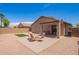 Inviting backyard with brick patio, gravel landscaping, and a charming seating area under the covered patio at 16274 N 138Th Ln, Surprise, AZ 85374