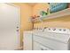 Functional laundry room equipped with a washer, dryer, and shelving for storage, adding convenience to daily chores at 16274 N 138Th Ln, Surprise, AZ 85374