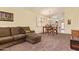 Comfortable living room with a brown couch, dining table, and natural light from a large window at 16274 N 138Th Ln, Surprise, AZ 85374