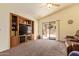 Bright living room with a built-in entertainment center, ceiling fan, and sliding glass doors to the patio at 16274 N 138Th Ln, Surprise, AZ 85374