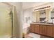 Well-lit bathroom features a glass shower and vanity with granite countertop at 16274 N 138Th Ln, Surprise, AZ 85374