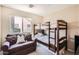 Comfortable bedroom featuring a bunk bed, sofa, and a well-lit window at 17244 W Mohave St, Goodyear, AZ 85338