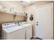 Practical laundry room with modern appliances, storage shelves, and convenient access at 17244 W Mohave St, Goodyear, AZ 85338