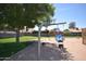 A bright community playground with swings, a slide, and a mature shade tree, perfect for outdoor fun at 1905 E Inverness Ave, Mesa, AZ 85204