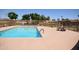 Community pool with clear blue water, surrounded by lounge chairs and manicured landscaping at 1905 E Inverness Ave, Mesa, AZ 85204