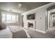 Serene main bedroom features a fireplace, ceiling fan, and ample natural light, creating a comfortable and relaxing retreat at 19922 N 101St Pl, Scottsdale, AZ 85255