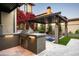Outdoor kitchen with built-in grill and adjacent spa, perfect for entertaining at 19922 N 101St Pl, Scottsdale, AZ 85255