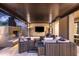 Covered outdoor living area with fireplace, TV, and comfortable seating at 19922 N 101St Pl, Scottsdale, AZ 85255