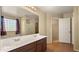 Bright bathroom featuring double sinks, large mirror, and adjacent walk-in closet for ample storage at 20426 N Alma Dr, Maricopa, AZ 85138