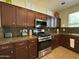 Modern kitchen featuring stainless steel appliances, granite countertops, and ample cabinet space at 20426 N Alma Dr, Maricopa, AZ 85138