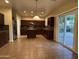 Gourmet kitchen with stainless steel appliances, a central island, custom cabinetry, and sliding glass doors to the backyard at 20426 N Alma Dr, Maricopa, AZ 85138