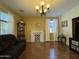 Elegant living room features a decorative fireplace, stylish chandelier, and ample natural light at 20426 N Alma Dr, Maricopa, AZ 85138