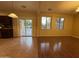 An open-concept living room featuring a seamless transition to the dining area and kitchen, with a glass sliding door to the backyard at 20426 N Alma Dr, Maricopa, AZ 85138
