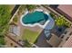 Aerial view of a backyard oasis featuring a freeform pool, lush landscaping, and comfortable seating area at 20426 N Alma Dr, Maricopa, AZ 85138