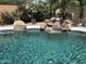 Inviting pool with rock waterfall feature and lush landscaping, perfect for relaxing and entertaining outdoors at 20426 N Alma Dr, Maricopa, AZ 85138