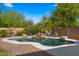 Sparkling backyard pool with rock waterfall and lush desert landscaping, creating a serene retreat at 20426 N Alma Dr, Maricopa, AZ 85138