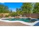 Backyard pool with rock waterfall and desert landscaping, offering a private and tranquil escape at 20426 N Alma Dr, Maricopa, AZ 85138
