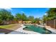 Inviting backyard oasis featuring a custom pool with rock waterfall, lush landscaping, and a pergola at 20426 N Alma Dr, Maricopa, AZ 85138