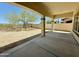 Relaxing covered patio with a backyard, privacy wall, and beautiful desert landscaping at 20472 W Daniel Pl, Buckeye, AZ 85396