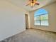 Sunlit bedroom features carpeted floors, ceiling fan, and a large arched window with blinds at 20472 W Daniel Pl, Buckeye, AZ 85396