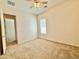 Bedroom featuring carpet floors, a ceiling fan, and an open closet with wood shelving at 20472 W Daniel Pl, Buckeye, AZ 85396