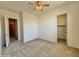 Spacious bedroom featuring carpet floors, a ceiling fan, and an open closet with wood shelving at 20472 W Daniel Pl, Buckeye, AZ 85396