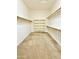 Spacious walk-in closet features neutral carpeting, built-in shelving, and hanging racks for storage at 20472 W Daniel Pl, Buckeye, AZ 85396