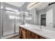 Well-lit bathroom featuring double sinks, a framed mirror, and a glass-enclosed shower at 21616 E Calle De Flores --, Queen Creek, AZ 85142