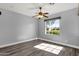 Cozy bedroom with hardwood floors, ceiling fan, and a large window offering natural light at 21616 E Calle De Flores --, Queen Creek, AZ 85142