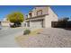 Tan two-story home featuring a spacious three-car garage and a mature tree in the front yard at 23104 W Kimberly Dr, Buckeye, AZ 85326