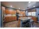 Well-lit kitchen features tan granite countertops, honey colored cabinetry, an island, and stainless steel appliances at 23104 W Kimberly Dr, Buckeye, AZ 85326