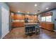 Well-lit kitchen features tan granite countertops, honey colored cabinetry, an island, and stainless steel appliances at 23104 W Kimberly Dr, Buckeye, AZ 85326