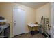 Spacious laundry room featuring a folding table and extra door at 23104 W Kimberly Dr, Buckeye, AZ 85326