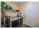 The laundry room has a modern washer and dryer, storage shelving, and access to outside at 23104 W Kimberly Dr, Buckeye, AZ 85326