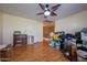Cluttered room with a ceiling fan, light walls, and wood flooring at 23104 W Kimberly Dr, Buckeye, AZ 85326