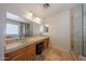 Well-lit main bathroom with a glass shower, bathtub, dual glass bowl vanity, and tile flooring at 23104 W Kimberly Dr, Buckeye, AZ 85326
