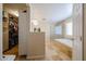 Bright main bathroom featuring tile flooring, bathtub, glass shower, and walk-in closet at 23104 W Kimberly Dr, Buckeye, AZ 85326