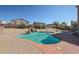 Backyard swimming pool with rock waterfall feature and partially shaded by the building at 23104 W Kimberly Dr, Buckeye, AZ 85326