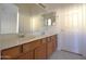 Bathroom offers a double sink vanity, large mirror, and tile floors for convenience and practicality at 2667 S 156Th Ave, Goodyear, AZ 85338