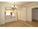 Open-concept dining area with stylish chandelier and view of the updated kitchen with stainless appliances at 2667 S 156Th Ave, Goodyear, AZ 85338
